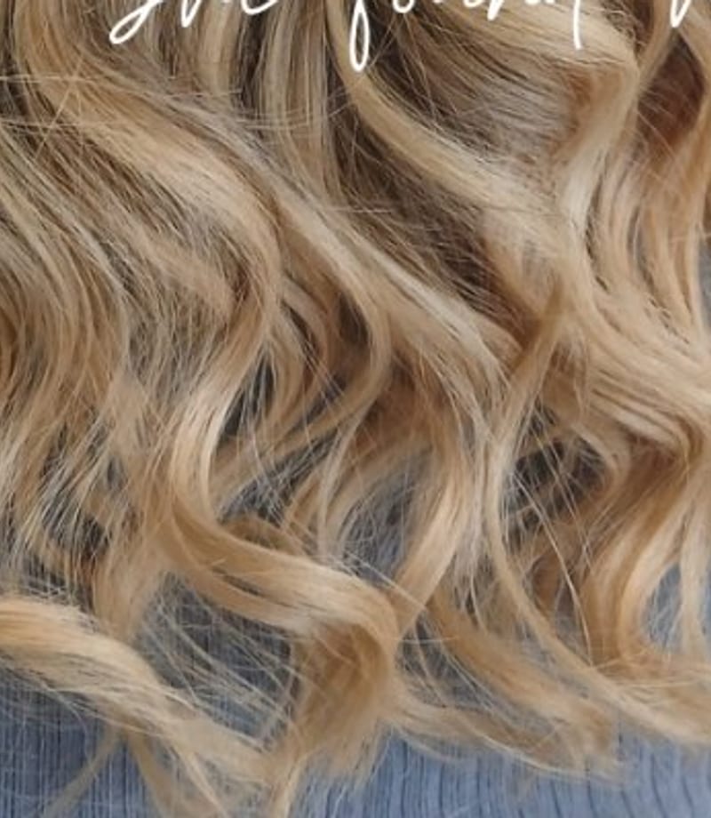 Long blonde waves being styled in the salon